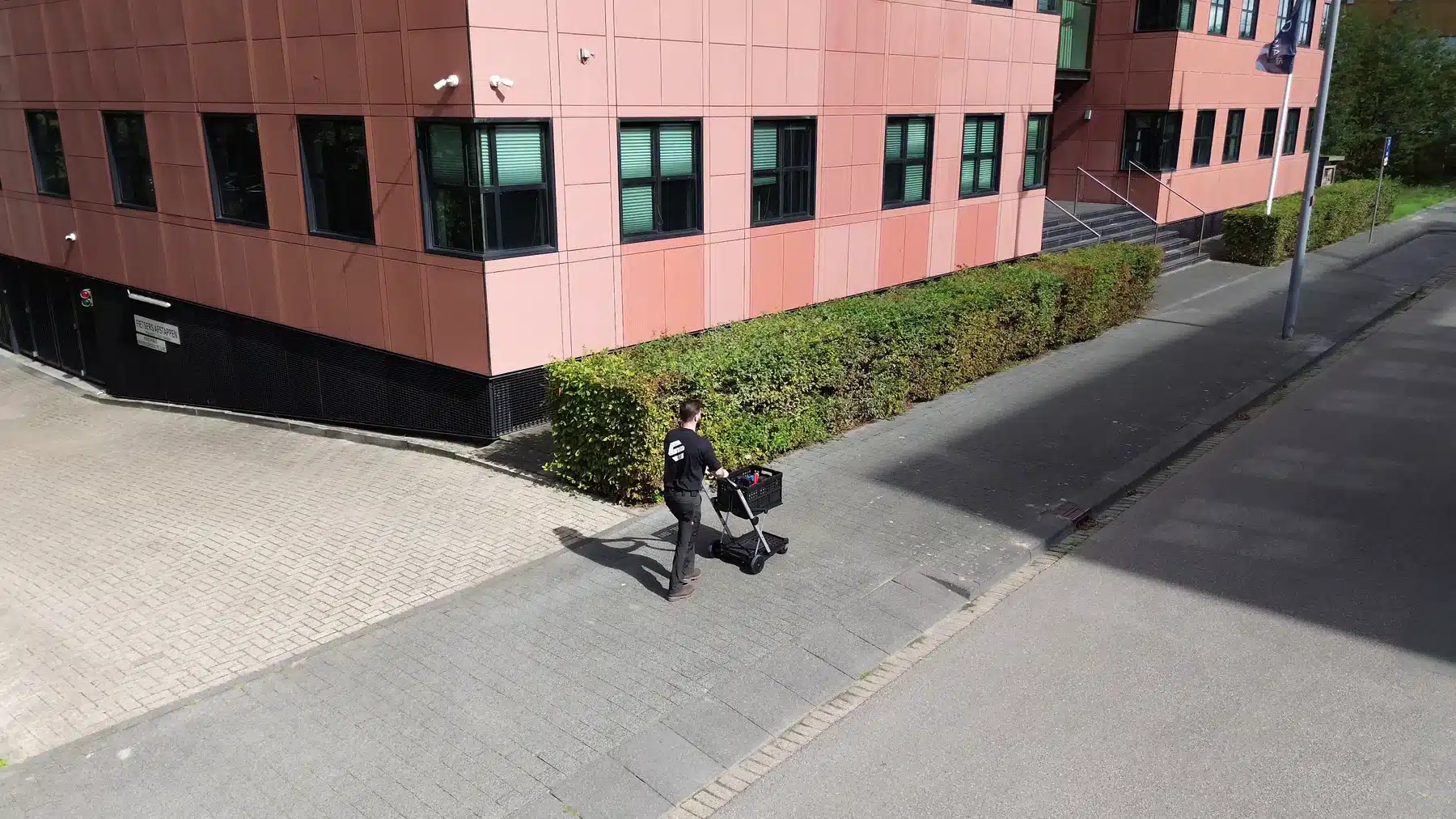 Elektrotechnisch inspectiebureau Enspect: inspecteur komt met de gereedschapskar aan bij een bedrijfspand